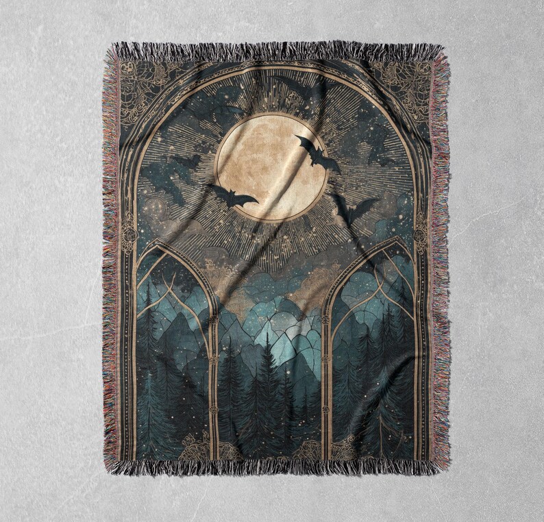 May include: A woven throw blanket featuring a gothic forest scene with a full moon, bats, and a starry sky. The design is framed by arched windows and detailed with fringe edges. The color palette includes shades of blue, brown, and gold.