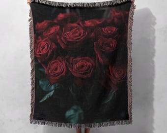 May include: A dark red and black woven throw blanket with a pattern of red roses.