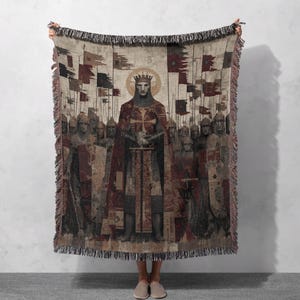 May include: Woven tapestry throw blanket featuring a medieval king with a crown, holding a sword, surrounded by soldiers and flags. The color palette includes shades of brown, red, and beige, with a fringed edge.