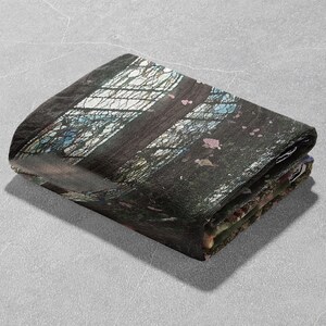 Pu&ograve; includere: Tessuto rettangolare piegato con un disegno stampato. Il disegno presenta un motivo a vetrata con sfumature di nero, bianco, blu e rosa. Il tessuto &egrave; piegato ordinatamente, mostrando la stampa dettagliata.