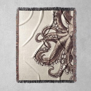 May include: A woven throw blanket featuring a brown and white octopus design. The octopus is drawn in a detailed style with many tentacles.