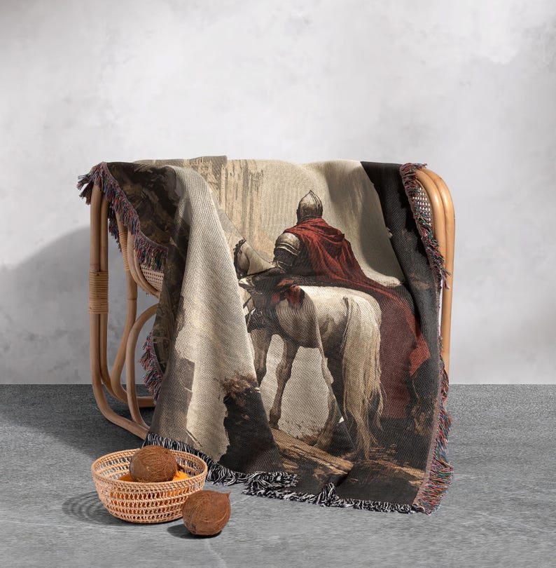 May include: A woven tapestry throw blanket features a medieval knight riding a white horse through a stone archway. The knight is wearing red armor and a red cape. The tapestry is brown, white, and red.