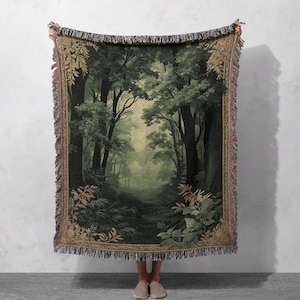 Könnte beinhalten: Eine gewebte Wandteppich-Decke mit einer grünen Waldszene und einem Weg, der in den Wald führt. Der Wandteppich hat einen goldenen und braunen Rand.