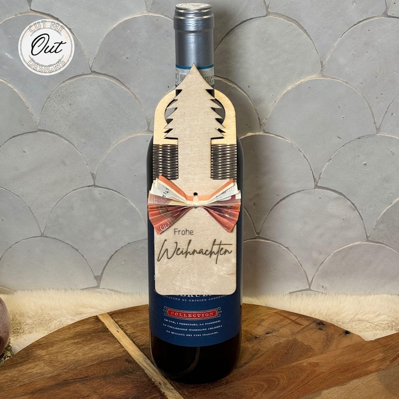 May include: A wooden Christmas tree wine bottle tag with a red bow and the text "Frohe Weihnachten".