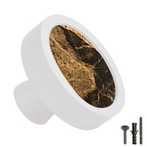 Peut inclure: Bouton de porte rond blanc avec un motif marbré or et noir. Le bouton a une petite tige pour la fixation à une porte de placard.