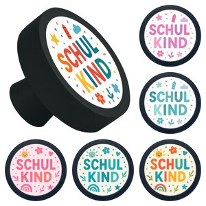 Peut inclure: Bouton de meuble noir avec un motif circulaire blanc portant l'inscription "SCHUL KIND" en lettres colorées, entouré d'illustrations d'étoiles, de fleurs et de crayons. D'autres boutons avec le même motif sont également présentés.