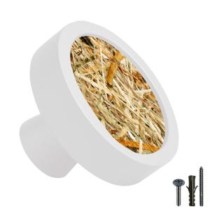 Peut inclure: Bouton de porte en céramique blanche avec un dessus rond et plat présentant un motif de camouflage de paille sèche brune et beige. Le bouton a une petite base ronde.