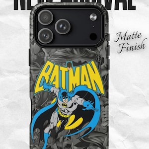 Könnte beinhalten: Schwarze Handyhülle mit einem Batman-Design in Gelb, Blau und Grau. Die Hülle hat eine matte Oberfläche und ist mit "MagSafe" gekennzeichnet. Die Worte "New Arrival" stehen oben und "Shop Now" unten.