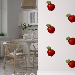 May include: A white wall with a repeating pattern of red apples with green leaves. The apples are arranged in a grid pattern.