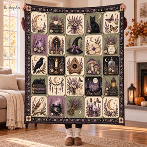 May include: A rectangular throw blanket featuring a grid of twenty square panels with mystical and botanical illustrations, including lavender bouquets, a black cat, a witch hat, a cauldron, an owl, a raven, crystals, and moons on a dark background.