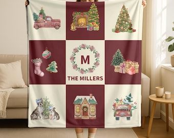 May include: A personalized Christmas-themed blanket with a patchwork design. The blanket features festive watercolor illustrations of Christmas trees, a red truck, a fireplace, gifts, and a house. The center square displays a floral wreath with the letter "M" and the name "THE MILLERS".