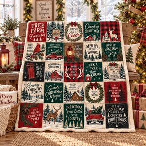 Op de afbeelding: Een pluche deken met een crèmekleurige rand, bestaande uit een raster van vijfentwintig feestelijke vierkanten. Elk vierkant toont kerstgerelateerde illustraties en teksten, waaronder een rode vrachtwagen, een hert, een lantaarn en dennenbomen.