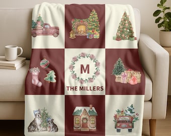 May include: A personalized Christmas-themed throw blanket with a patchwork design. The blanket features watercolor illustrations of a red truck with a Christmas tree, a fireplace, a Christmas tree, and other festive elements. The text "THE MILLERS" is also displayed.