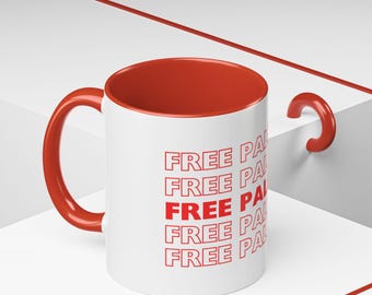 May include: White ceramic mug with a red interior and handle. The mug has the text "FREE PAL" repeated five times in red.