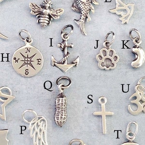 May include: A collection of 16 silver charm pendants, each featuring a different design. The charms include a bee, a fish, a compass, an anchor, a paw print, a crescent moon, a star, a peanut, a cross, a heart, a horseshoe, and an Om symbol.