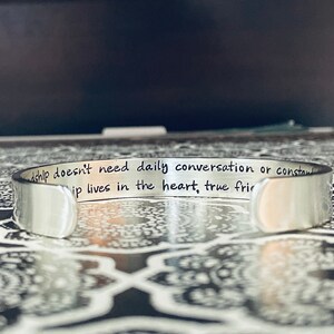 May include: Silver bracelet with the inscription "Friendship doesn't need daily conversation or constant contact, true friendship lives in the heart, true friends are always there".
