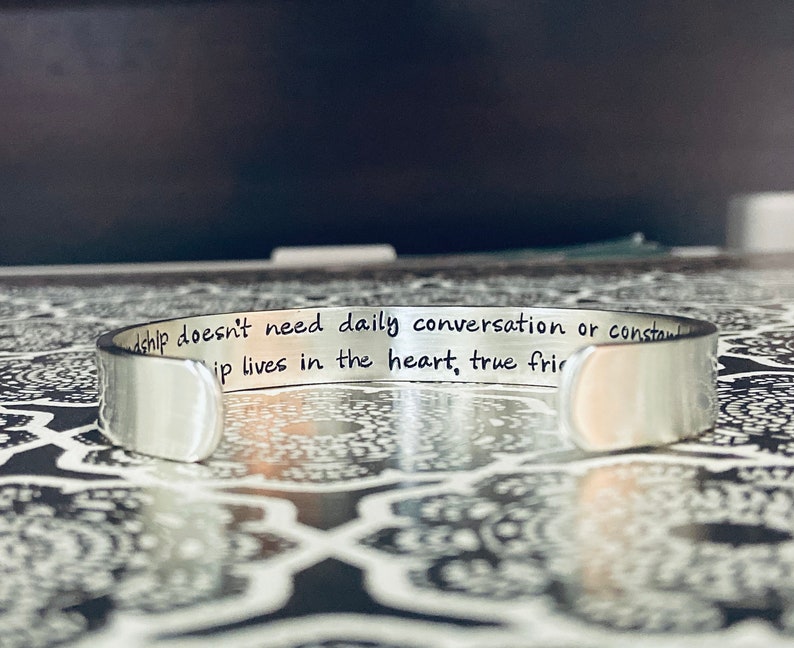 May include: Silver bracelet with the inscription "Friendship doesn't need daily conversation or constant contact, true friendship lives in the heart, true friends are always there".