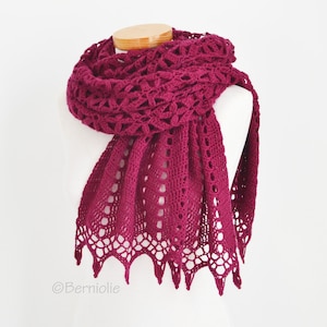 May include: A burgundy crochet shawl with a delicate lace pattern. The shawl is draped over a white mannequin.