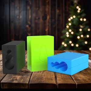 May include: Three different colored silicone molds for making snowman-shaped soap or candles. The molds are black, green, and blue.