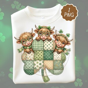 May include: White sweatshirt featuring a graphic of three Highland cows with shamrock accessories, holding a patchwork shamrock. The cows wear glasses and scarves. The design includes green, beige, and white colors. A brown circle with the text "1 PNG" is in the upper right corner.