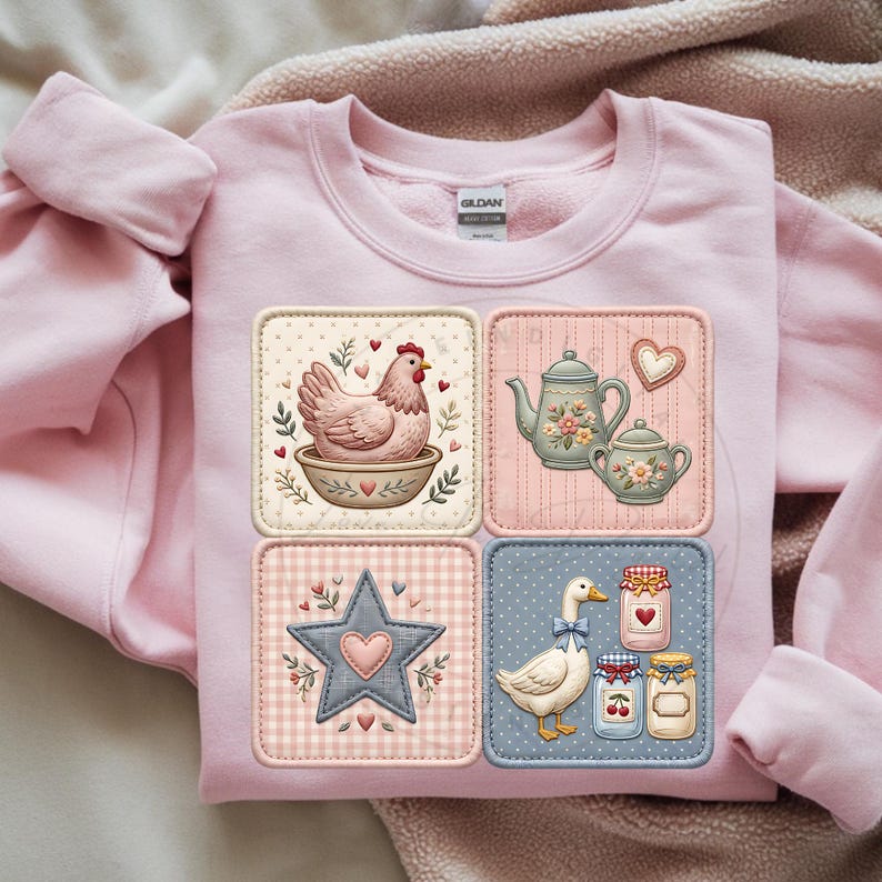 Puede incluir: Una sudadera rosa claro con un dise&ntilde;o de patchwork con ilustraciones de tem&aacute;tica rural. Los parches incluyen una gallina en un cuenco, una tetera y una taza de t&eacute;, una estrella y un ganso con tarros de conservas. El dise&ntilde;o tiene una est&eacute;tica vintage y campestre.