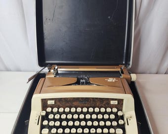 Máquina de escribir manual portátil Sears Cutlass vintage de los años 60, color cobre metálico, tipo Pica, con estuche de transporte.