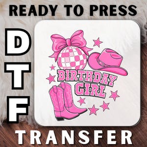 May include: A DTF transfer design featuring a pink disco ball with a bow, a cowboy hat, and boots. The words "BIRTHDAY GIRL" are in the center, with stars scattered around. The words "READY TO PRESS" and "TRANSFER" are at the top and bottom.
