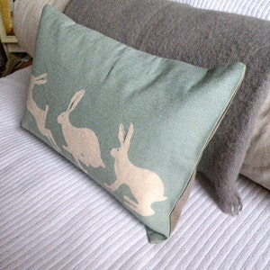 Handprinted duck egg triptyque hares cushion cover