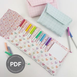 May include: A fabric pencil case with a star pattern and a heart pattern, holding colorful markers. Two matching fabric pouches are in the background. The pencil case has a white notepad and the text "PDF" in a circle.