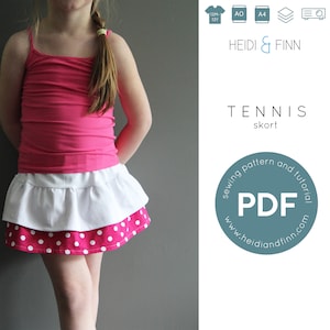 Puede incluir: Un patrón de costura y un tutorial para una falda pantalón de tenis, disponible para descargar en PDF. El patrón es para tallas de 12 meses a 12 años. La imagen muestra a una niña pequeña con una camiseta de tirantes rosa y la falda pantalón terminada, que es blanca con un volante de lunares rosas.