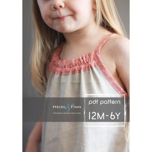 May include: A PDF pattern for a sleeveless dress for children, sizes 12 months to 6 years. The pattern is from Heidi & Finn, Modern Wear for Kids. The dress is shown in a light beige fabric with a pink trim.