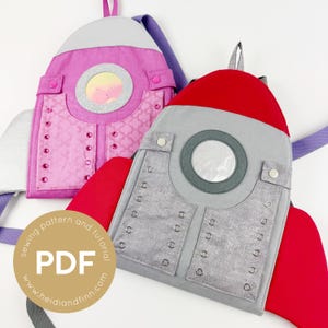 Op de afbeelding: Twee handgemaakte rugzakken in de vorm van een raket. Eén is roze met een zilveren raam en de andere is grijs met een rode bovenkant. Beide hebben zilveren accenten en bandjes. De afbeelding bevat een PDF-naaipatroon en een tutorial.