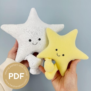 Op de afbeelding: Twee ster-vormige pluche speelgoed, één wit met zilveren glitter en de andere geel, elk met een lachend gezicht. De witte ster heeft een vijfpunts ontwerp, terwijl de gele ster een rondere vorm heeft. De afbeelding bevat de tekst "sewing pattern and tutorial" en "PDF".