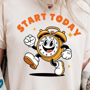 Camiseta retro con diseño de despertador vintage y estilo de dibujos animados de la vieja escuela con cita motivacional.