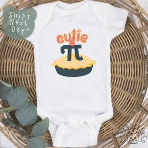 May include: White baby onesie with a pie graphic and the text "cutie pi".