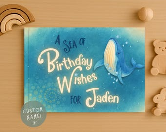 May include: A children's book with a blue cover featuring a whale illustration. The book's title reads "A Sea of Birthday Wishes for Jaden" in white script. A circular sticker reads "Custom Name!" on the bottom left.