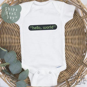 May include: White baby onesie with a black and green graphic that says "hello, world" in a code-like font.