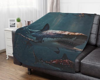 May include: A plush blanket featuring a detailed underwater scene with two sharks. The blanket showcases a realistic depiction of the ocean environment, with the sharks as the focal point. The color palette includes shades of blue, white, and brown.