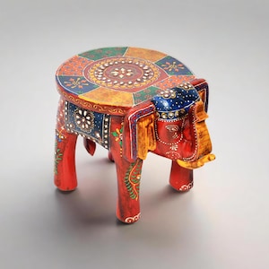 May include: A hand-painted wooden elephant stool. The stool is red with intricate floral and geometric patterns in blue, green, yellow, and orange. The elephant's head and ears are detailed with gold accents. The round seat is 30 cm in diameter.