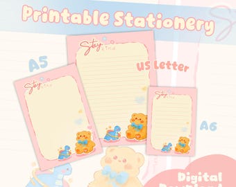 Pode incluir: Conjunto de papelaria imprimível rosa com o texto "Printable Stationery" e "Digital Download". O conjunto inclui blocos de notas A5, US Letter e A6 com um design de urso de pelúcia e dinossauro. Os blocos de notas têm o texto "Stay Kind".