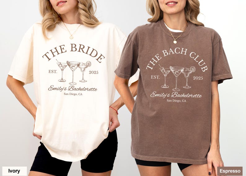 May include: Two t-shirts, one ivory and one espresso, featuring a cocktail design. The ivory shirt reads "THE BRIDE" with "Emily's Bachelorette" and "San Diego, CA." The espresso shirt says "THE BACH CLUB."