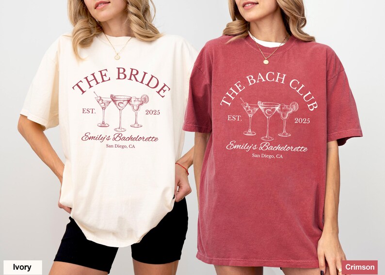 May include: Ivory and crimson-colored t-shirts with the text "THE BRIDE" and "THE BACH CLUB" printed on them. Each shirt features cocktail glasses, the year "2025", and "Emily's Bachelorette, San Diego, CA".