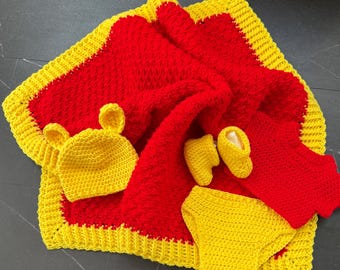 May include: A crocheted baby set in red and yellow. The set includes a blanket, hat, booties, and a diaper cover.