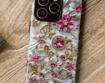 May include: A smartphone case featuring a three-dimensional embossed design of white and pink flowers, gold filigree swirls, and embedded bright pink crystals. The case has a black camera cutout area with three circular lenses and a flash.