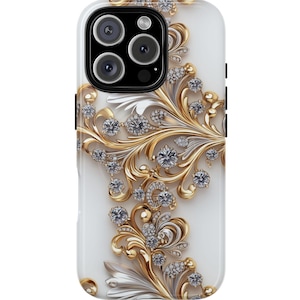 May include: A white phone case with a gold and silver floral design. The case features a detailed pattern of swirling leaves, embellished with sparkling diamond-like accents. The camera area is black, with three lenses.