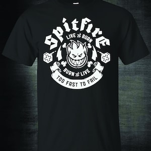 May include: Black t-shirt with a white graphic of a skull with flames and the text "Spitfire Live to Burn Burn to Live Too Fast to Fail".