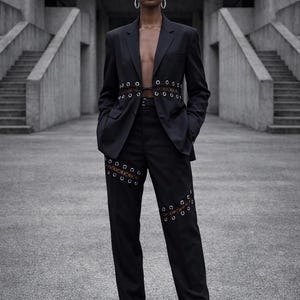 Traje transformable con ojales y cintura ajustable con cordones: chaqueta corta o larga, atuendo vanguardista.