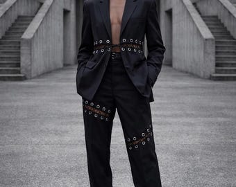 Traje transformable con ojales y cintura ajustable con cordones: chaqueta corta o larga, atuendo vanguardista.