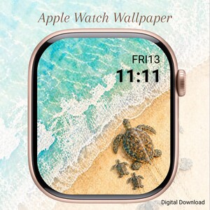 Può includere: Un Apple Watch con uno sfondo a tema spiaggia. Lo schermo mostra un oceano turchese, una spiaggia sabbiosa e tartarughe marine. L'ora è 11:11 e la data è venerdì 13. L'orologio ha una cassa color oro.