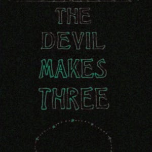 May include: Black graphic with the text "THE DEVIL MAKES THREE" in a stylized font. The text is outlined in a glowing teal color, with decorative elements above and below the text.